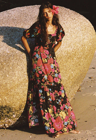  wearing a black maxi dress with a vibrant pink
